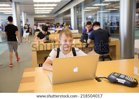 HONG KONG, CHINA - JUNE 15, 2014: Young shopper at Apple store in Hong Kong. Store is in a shopping center IFC Mall, it is very popular with locals and tourists visiting Hong Kong.