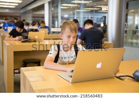 HONG KONG, CHINA - JUNE 15, 2014: Young visitor at Apple store in Hong Kong. Store is in a shopping center IFC Mall, it is very popular with locals and tourists visiting Hong Kong.