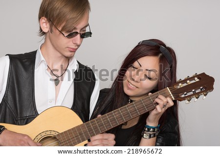 Young musicians sing a song. Interracial young couple, Asian woman and Caucasian man.