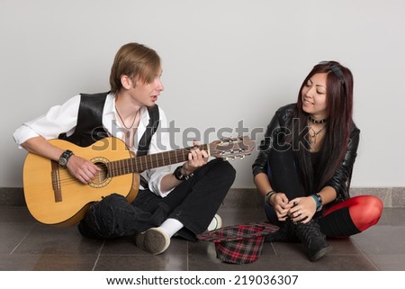Interracial young couple music. Asian woman and Caucasian man.