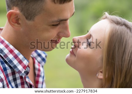 Happy young man and woman looking at each other against a background of trees