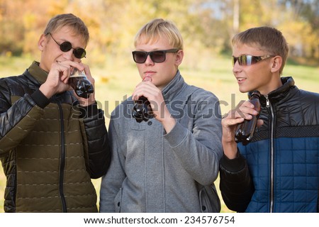 Group of young guys drink beverages and communicate with each other. Two of the boys twin brothers. Image with Instagram-like filter