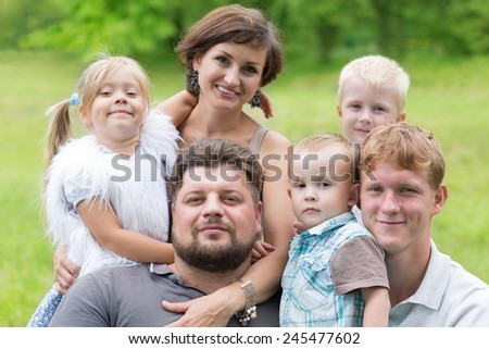 Big happy family - parents with four children in a summer park