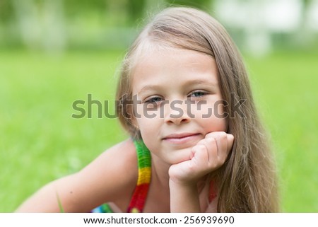 Portrait of girl with curious look in the park. Girl seven years.
