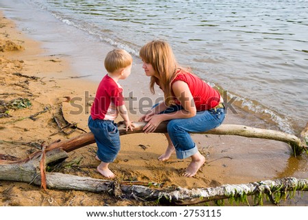 Mom and the son talk at the sea.Evening.