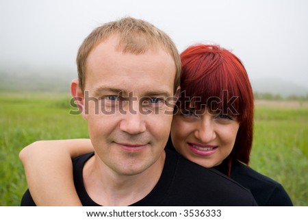 Happy young married couple on the nature. On a background a fog.