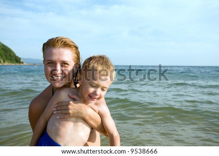 Mother bathes in the sea with the son