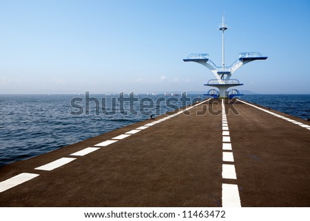 Pier.Tower for jumps in water.On horizon of a yacht.