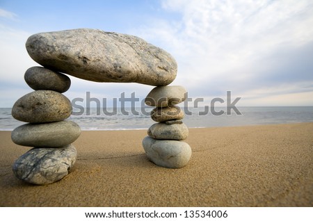 Abstract triumphal arch from a natural stones on a background of the sea