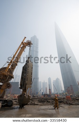 Shanghai city. China. In the foreground the beginning of construction of new office building. June, 2009.