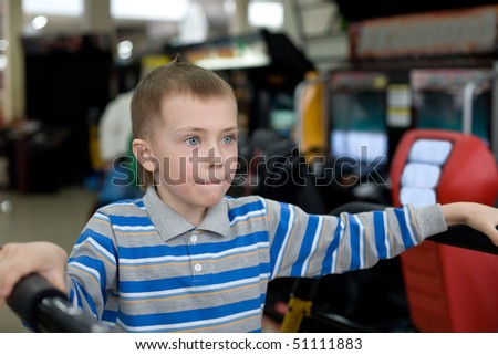 Boy in the children\'s amusement arcade. Playing a video game.