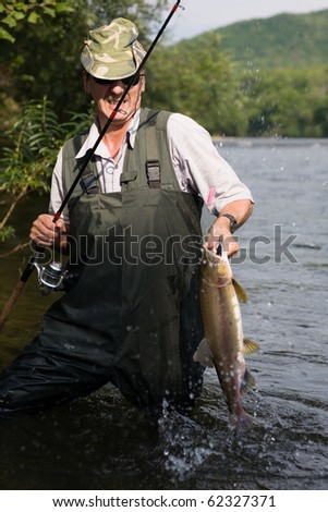 Fisherman catches of salmon (pink salmon) on the river.
