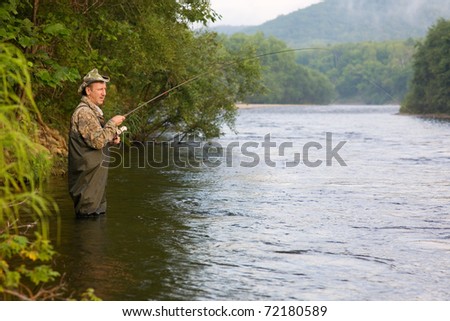 Fisherman catches of salmon (pink salmon) on the river. Early morning.