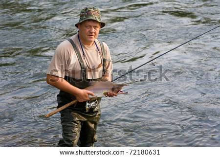 Fisherman caught a salmon (pink salmon) on the River. Early morning.