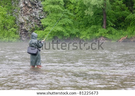 Fisherman catches of salmon on a mountain river. Is rain. Fog.
