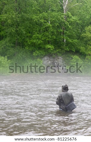 Fisherman catches a salmon river. Fog. Is rain.