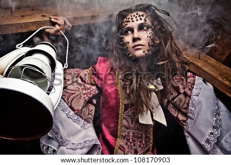 Fine art photo of a young fashion lady in a dark mystic location.