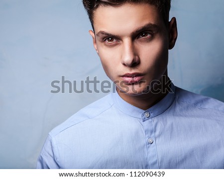 Elegant young handsome man on grunge background. Studio fashion portrait.