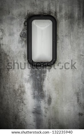 Outdoor lamp on grunge stone wall.