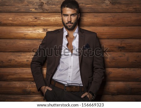 Portrait Of Young Beautiful Fashionable Man Against Wooden Wall.