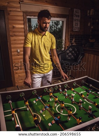 Young handsome man in yellow t-shirt playing on soccer.