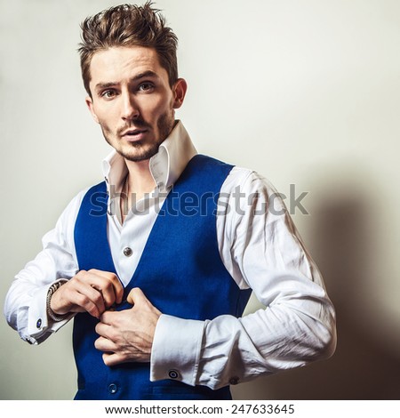 Elegant young handsome man in white shirt & vest. Studio fashion portrait.