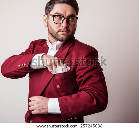 Elegant young handsome man in luxury red costume. Studio fashion portrait.