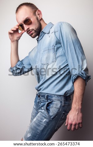 Young handsome man in jeans clothes. Studio fashion portrait.