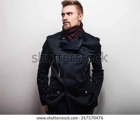 Elegant young handsome man in black coat. Studio fashion portrait.