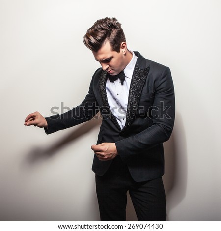 Elegant young handsome man in black luxury costume. Studio fashion portrait.