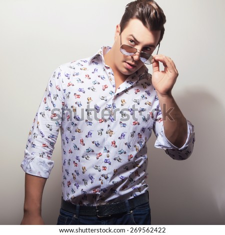 Elegant young handsome man in bright colorful shirt. Studio fashion portrait.
