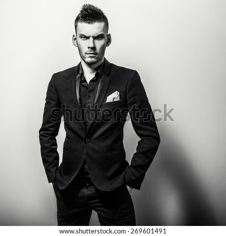 Elegant young handsome serious man in classic costume. Black-white studio fashion portrait.
