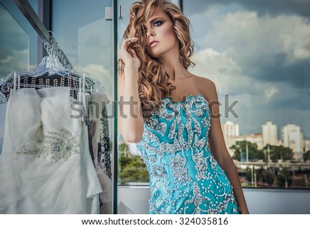 Elegant young beauty woman in luxury dress posing indoor. Fashion photo.