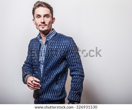 Elegant young handsome man in stylish dark blue jacket. Studio fashion portrait.