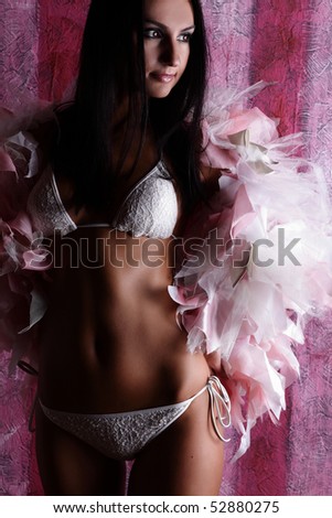 Dramatic lighting shot of a beautiful&sexy woman with lingerie on a pink background.