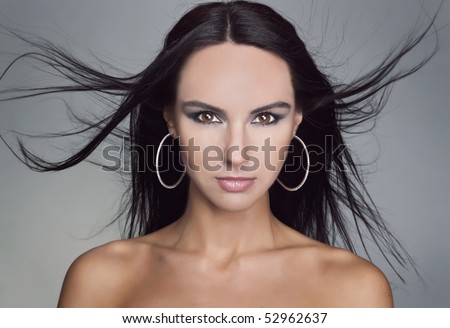 Fashion model with hair blowing in the wind. Close-up portrait.