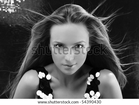Fashion model with hair blowing in wind. Close-up portrait.
