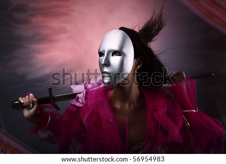 Woman warrior in a silver mask with a sword in hands. Photo.