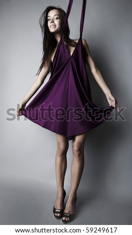 Sexy brunette posing in silk violet dress.