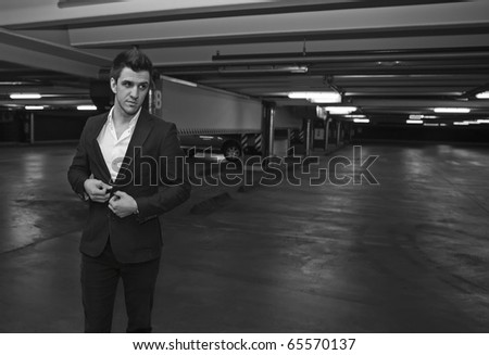 A Businessman getting out of a car in a parking lot