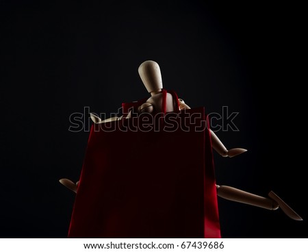 Wooden doll figure isolated on black background.