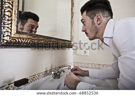 Man takes a look at himself in the mirror.