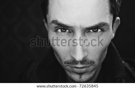Close-up portrait of attractive man with deep sight. Black-white photo.