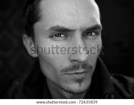 Close-up portrait of attractive man with deep sight. Black-white photo.