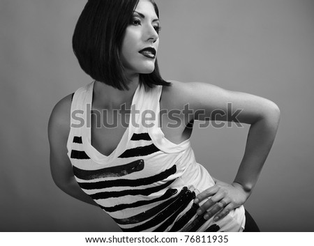 Beautiful brunette with an accurate hairdress dressed in a striped t-shirt. Black-white photo.