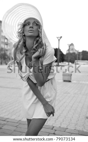 Portrait of a beautiful model in white retro hat. Street fashion Black-white photo.