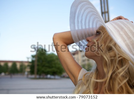Portrait of a beautiful model in white retro hat. Street fashion photo.