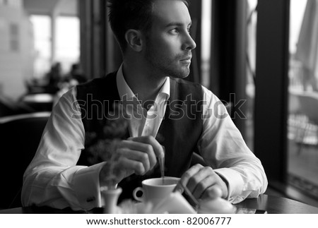 young attractive businessman has coffee a pause. Black-white photo.