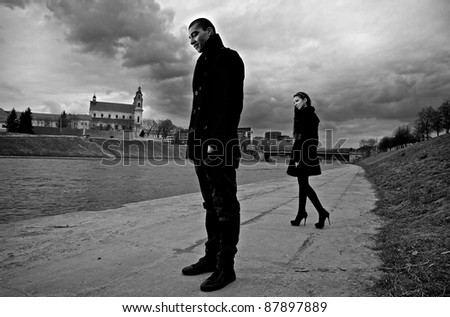 Beautiful stylish pair of young people outdoor going in different directions.