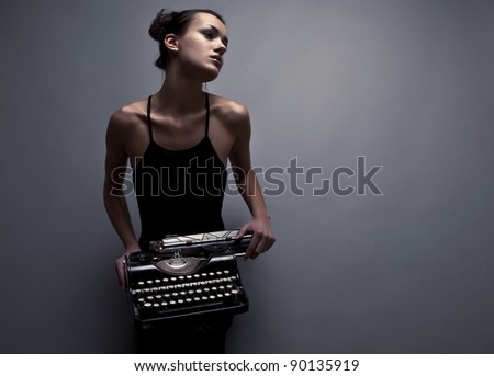 Elegant woman pose with ancient typewriter. Conceptual fashion photo.